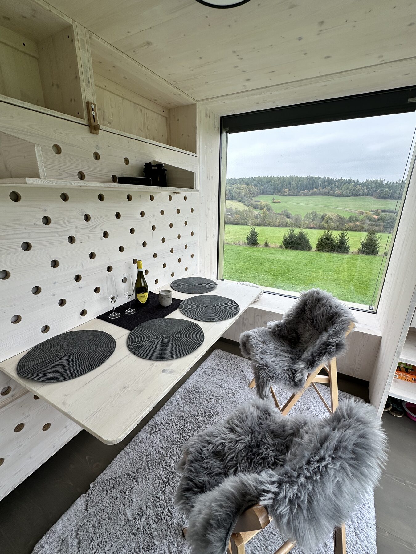 Útulný interiér obytného posedu se sklopeným stolem, Glamping od Amy